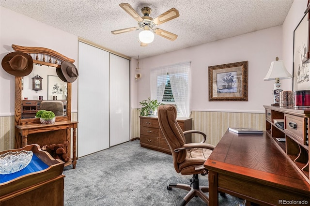 office area featuring light carpet, a textured ceiling, ceiling fan, and wooden walls