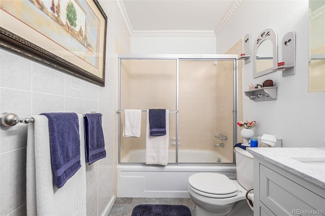 full bathroom featuring tile patterned floors, ornamental molding, bath / shower combo with glass door, tile walls, and toilet