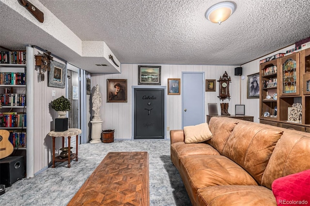 living room with light colored carpet, a textured ceiling, and wooden walls