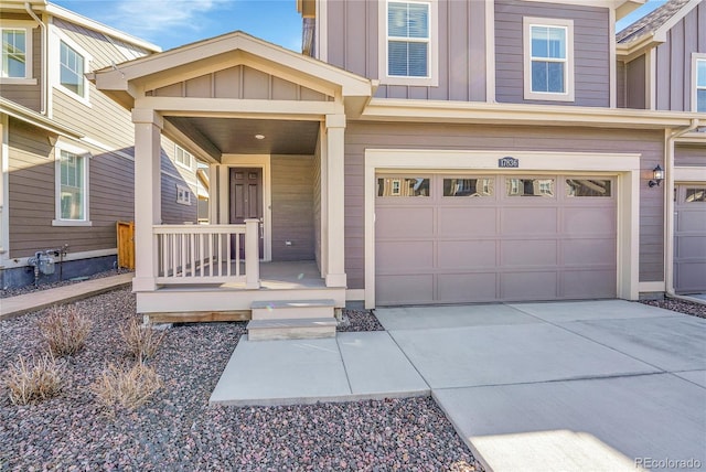 entrance to property featuring board and batten siding, concrete driveway, covered porch, and a garage