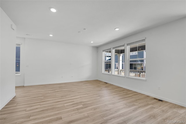 spare room with light wood finished floors, baseboards, visible vents, and recessed lighting