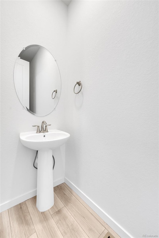 bathroom featuring wood finished floors and baseboards