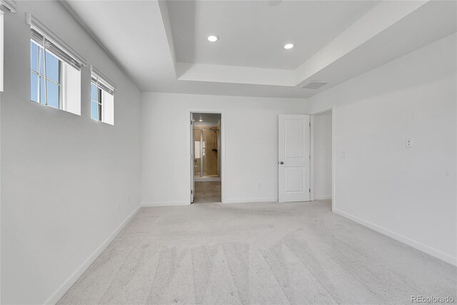 spare room with recessed lighting, light colored carpet, visible vents, baseboards, and a tray ceiling