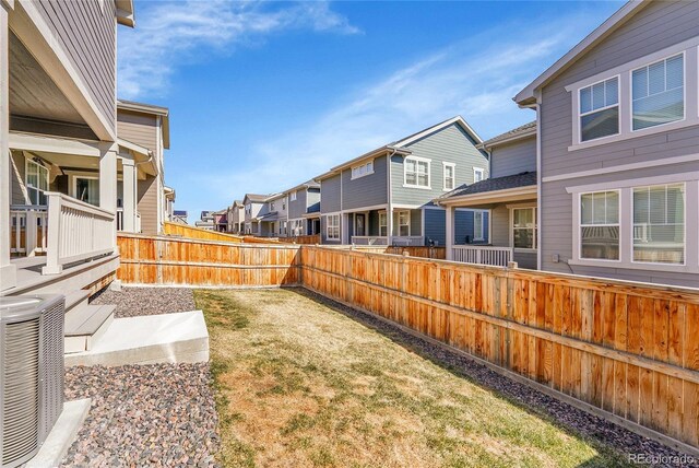 view of yard featuring cooling unit, a residential view, and fence