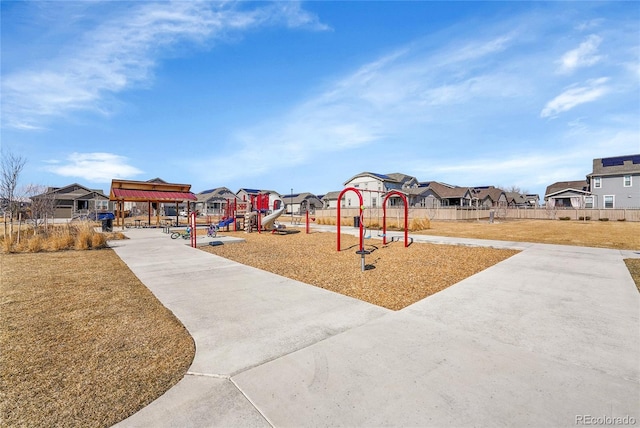 community play area with a residential view, a lawn, and fence