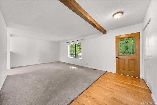 19398 E Eastman Pl, Aurora, CO 80013 - entrance foyer featuring beamed ceiling, a textured ceiling, baseboards, and light wood finished floors