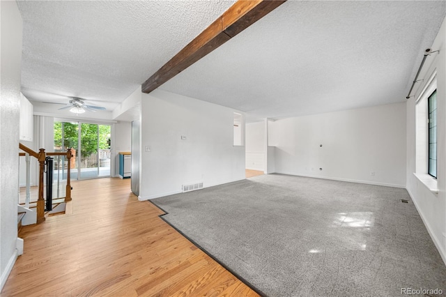 19398 E Eastman Pl, Aurora, CO 80013 - unfurnished living room with a textured ceiling, beam ceiling, a ceiling fan, baseboards, and light wood finished floors