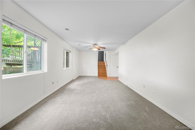 19398 E Eastman Pl, Aurora, CO 80013 - spare room with light carpet, stairway, ceiling fan, and baseboards
