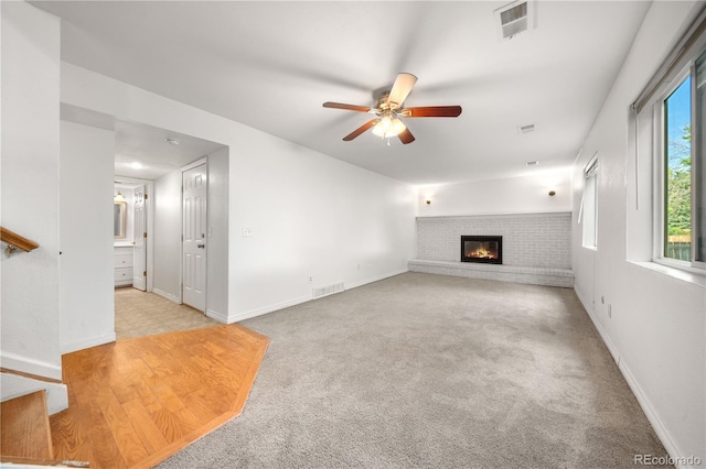 19398 E Eastman Pl, Aurora, CO 80013 - unfurnished living room with ceiling fan, a brick fireplace, carpet floors, and baseboards