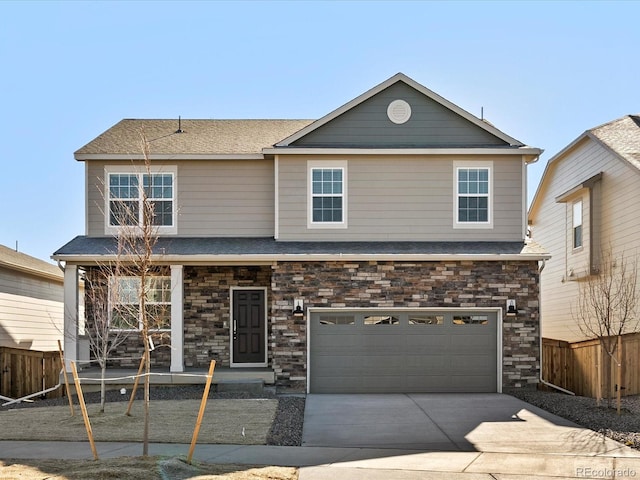 traditional-style home with a garage, stone siding, fence, and driveway