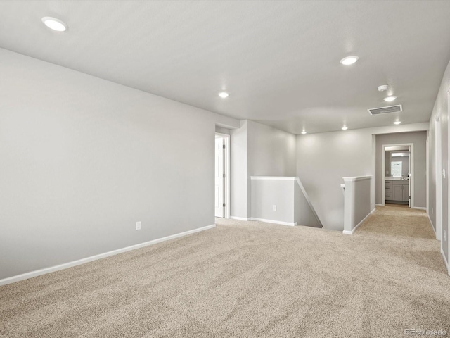 spare room with recessed lighting, visible vents, light carpet, and baseboards