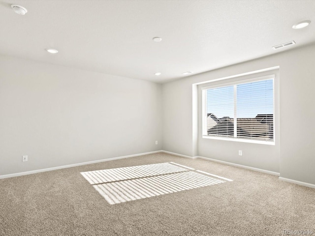 spare room with carpet, visible vents, baseboards, and recessed lighting