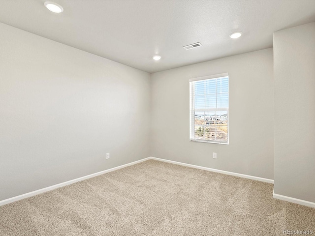 carpeted spare room with recessed lighting, visible vents, and baseboards