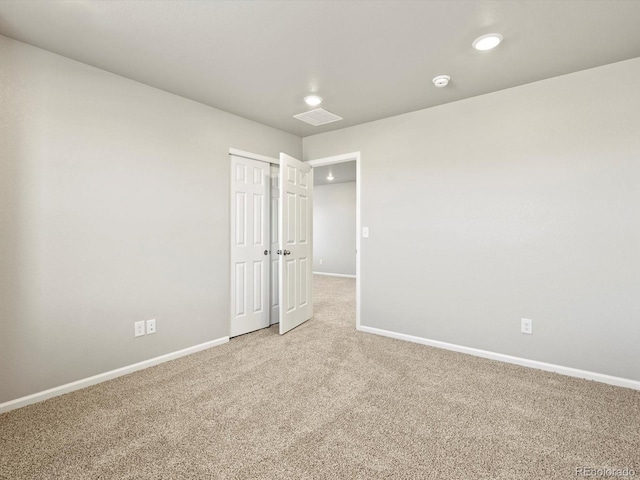 empty room with light carpet, visible vents, and baseboards