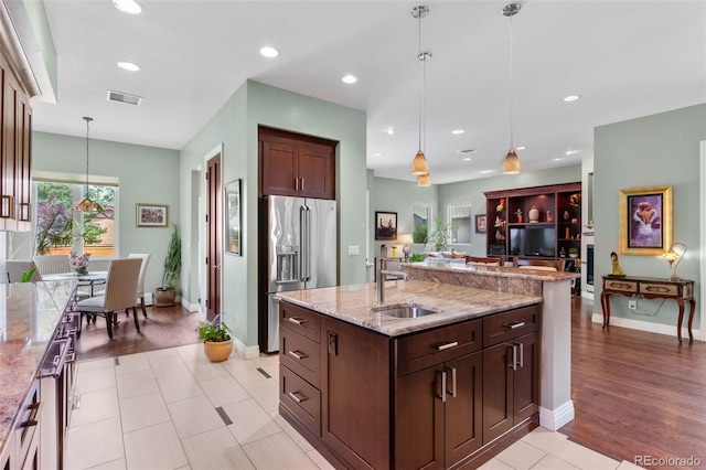 1344 S Saint Paul St, Denver, CO 80210 - kitchen with high quality fridge, decorative light fixtures, light stone counters, recessed lighting, and a kitchen island with sink