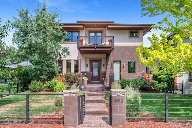1344 S Saint Paul St, Denver, CO 80210 - view of front of property featuring a balcony, a fenced front yard, and stucco siding
