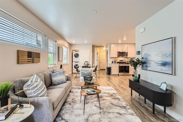 65 Avocet Ct, Longmont, CO 80501 - living room featuring stacked washer / dryer, light wood-style flooring, and recessed lighting