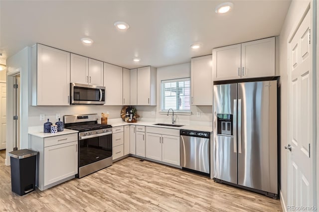 65 Avocet Ct, Longmont, CO 80501 - kitchen featuring appliances with stainless steel finishes, a sink, light countertops, light wood-style flooring, and recessed lighting