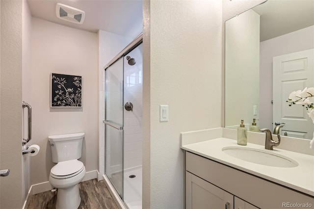 65 Avocet Ct, Longmont, CO 80501 - full bath featuring toilet, vanity, a shower stall, and wood finished floors