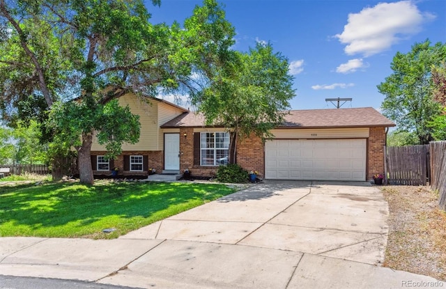 5372 E 108th Pl, Thornton, CO 80233 - tri-level home with an attached garage, brick siding, and driveway