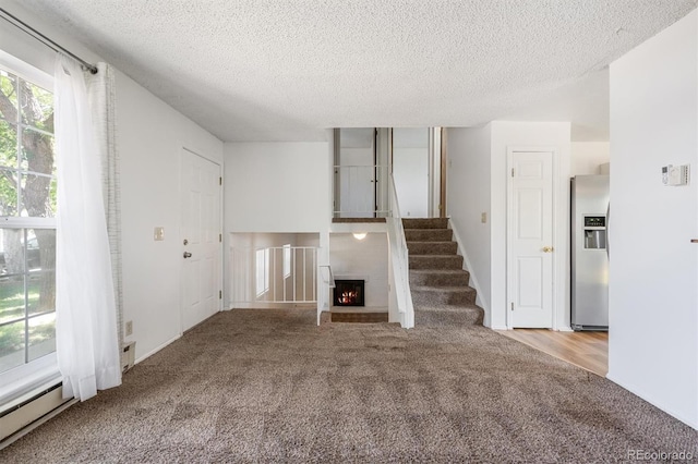 5372 E 108th Pl, Thornton, CO 80233 - unfurnished living room with carpet floors, a textured ceiling, and a lit fireplace