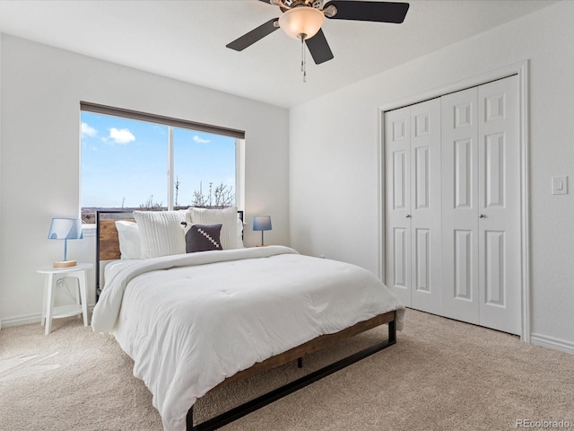 carpeted bedroom with a closet, baseboards, and ceiling fan