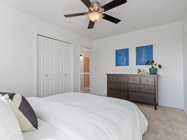 bedroom with a closet, baseboards, a ceiling fan, and carpet flooring