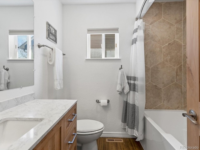 full bath featuring visible vents, baseboards, toilet, wood finished floors, and vanity