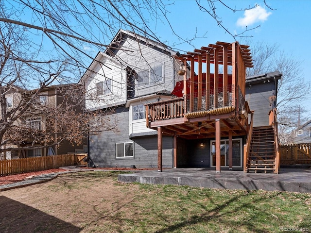 back of property with a deck, a patio, stairway, and fence