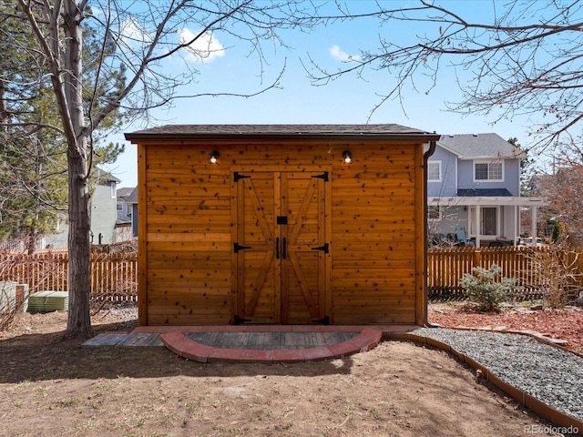 view of shed featuring fence