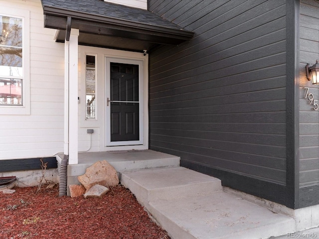 property entrance featuring roof with shingles