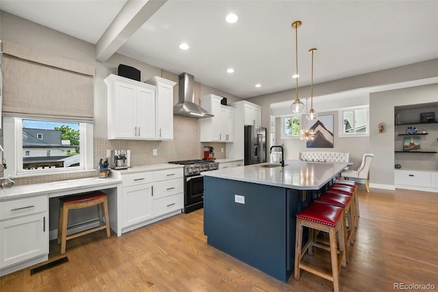 2805 S Sherman St, Englewood, CO 80113 - kitchen featuring wall chimney range hood, high end appliances, white cabinets, a kitchen bar, and tasteful backsplash