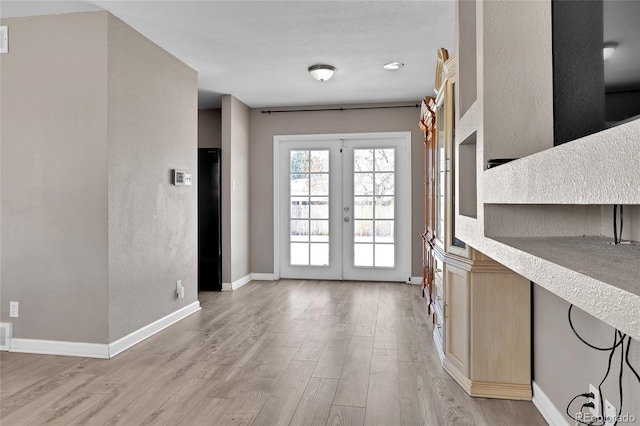 foyer with light hardwood / wood-style flooring and french doors