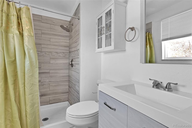 bathroom featuring toilet, vanity, and walk in shower