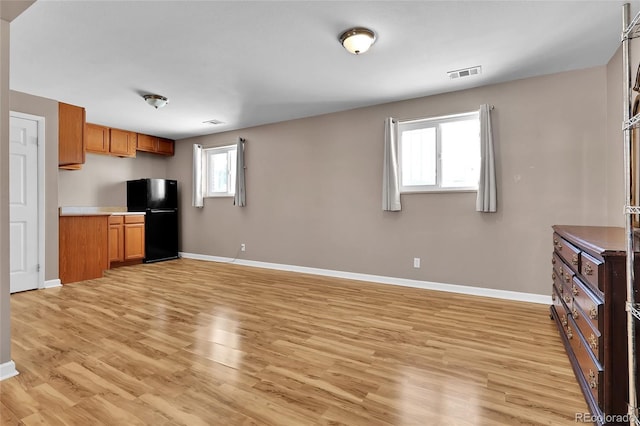 kitchen featuring light hardwood / wood-style flooring and black fridge