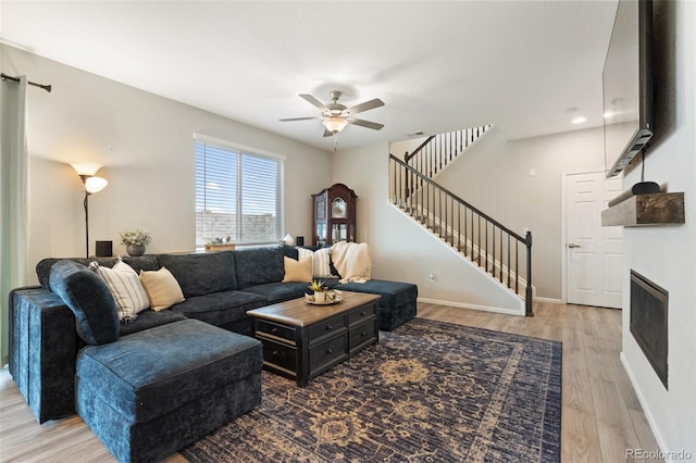 16369 Alberta Dr, Parker, CO 80134 - living room with ceiling fan, stairs, wood finished floors, baseboards, and a glass covered fireplace