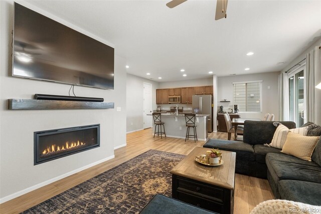 16369 Alberta Dr, Parker, CO 80134 - living area with recessed lighting, light wood finished floors, a glass covered fireplace, baseboards, and a ceiling fan