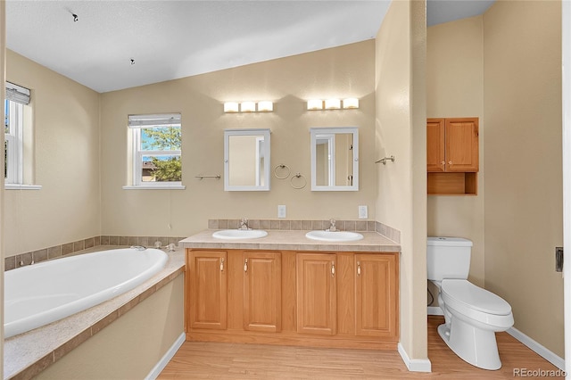 7870 Sunflower Grn Unit 151, Frederick, CO 80530 - bathroom featuring wood finished floors, toilet, a garden tub, vaulted ceiling, and double vanity