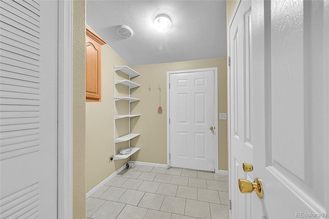 7870 Sunflower Grn Unit 151, Frederick, CO 80530 - mudroom featuring light tile patterned floors, baseboards, and a textured ceiling