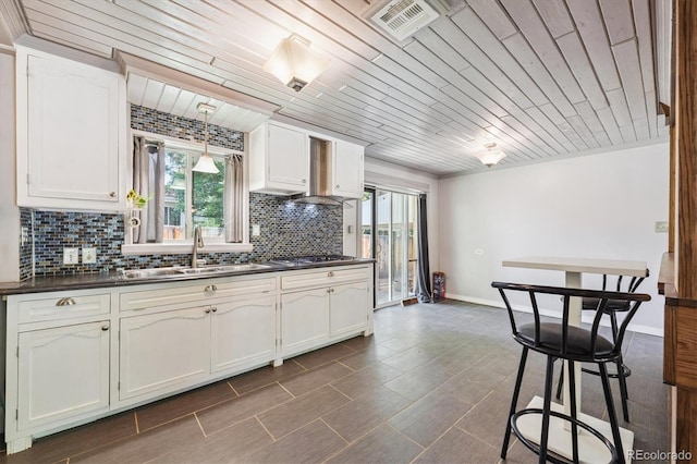 100 Dudley St, Lakewood, CO 80226 - kitchen featuring dark countertops, healthy amount of natural light, backsplash, wood ceiling, and white cabinets