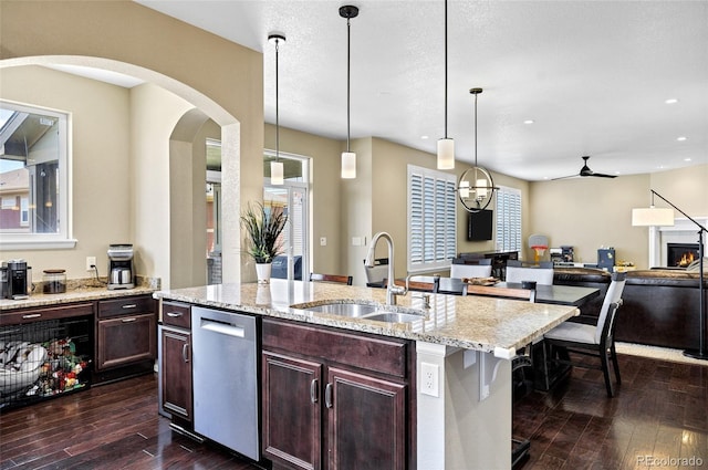 kitchen featuring a sink, dishwasher, dark wood-style floors, ceiling fan, and arched walkways