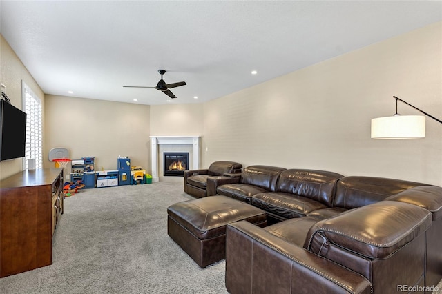 carpeted living area featuring ceiling fan, a glass covered fireplace, and recessed lighting
