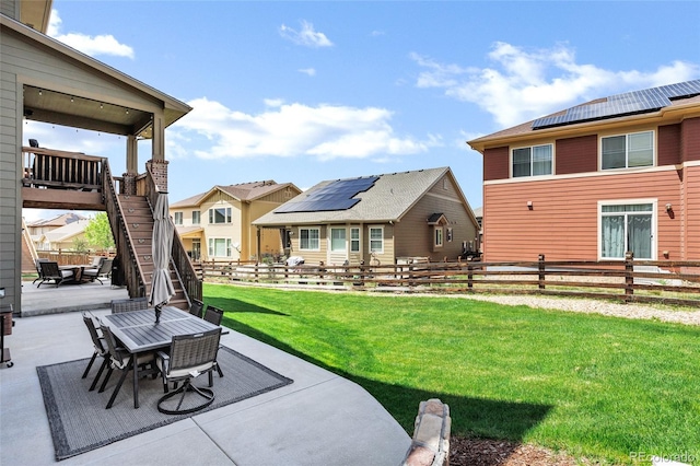 view of yard with a patio area, outdoor dining space, stairway, and a residential view