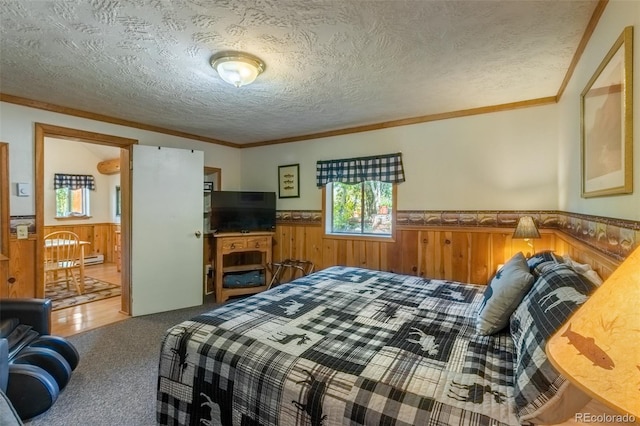 carpeted bedroom with crown molding, a textured ceiling, and wood walls