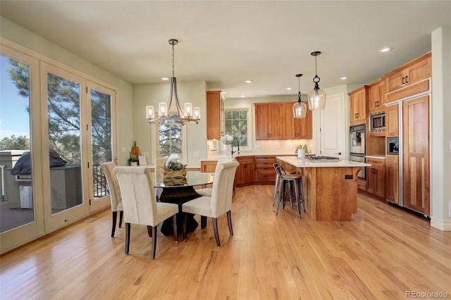 dining room with recessed lighting, light wood finished floors, and a chandelier