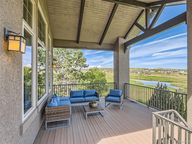 wooden deck with outdoor lounge area and a water view