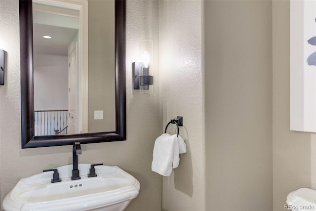 half bathroom featuring a sink and toilet