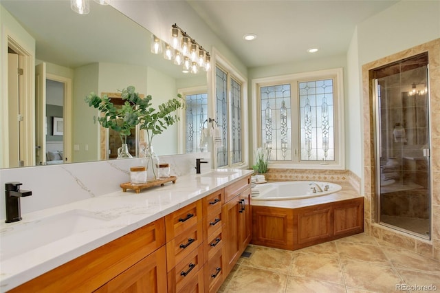 bathroom featuring a bath, a shower stall, double vanity, and a sink