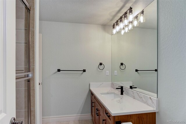 bathroom with a shower with shower door, baseboards, a textured ceiling, and vanity