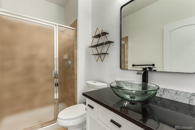 bathroom featuring vanity, toilet, and walk in shower